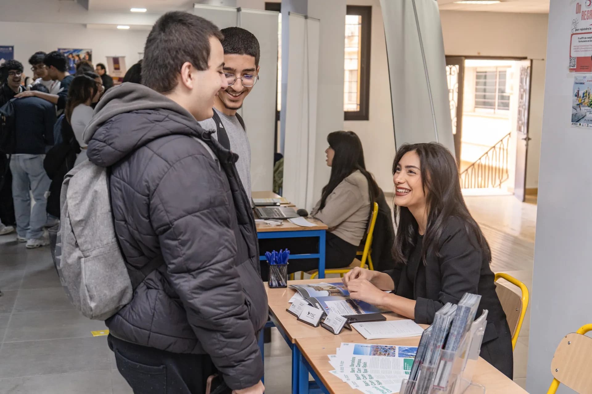 Conseillère TISC échangeant avec des étudiants sur un salon étudiant